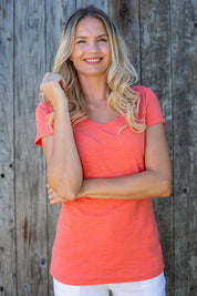 A model wearing the Cockles Tee in colour Papaya (Pink), from the front, showing the whole outfit