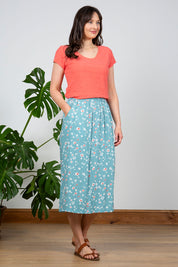 A model wearing the Cockles Tee in colour Papaya (Pink), from the front, showing the whole outfit