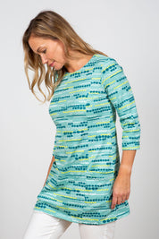 A model wearing the Harriet Tunic in colour Seafoam (Green), from the front, cropped image