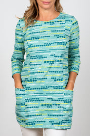 A model wearing the Harriet Tunic in colour Seafoam (Green), from the front, cropped image