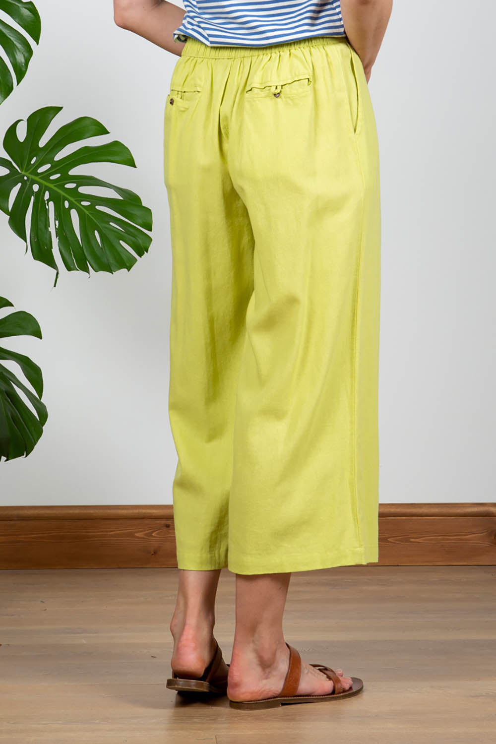 A model wearing the Summer Trouser in colour Citron, from the back