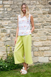 A model wearing the Summer Trouser in colour Citron, from the front, showing the whole outfit