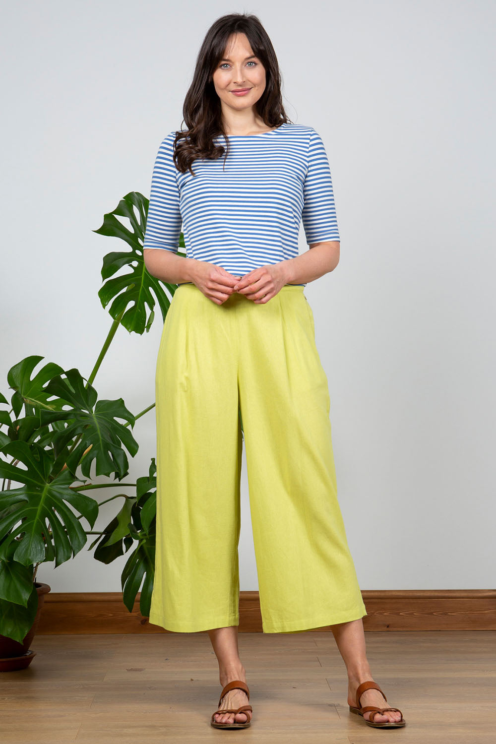 A model wearing the Summer Trouser in colour Citron, from the front, showing the whole outfit