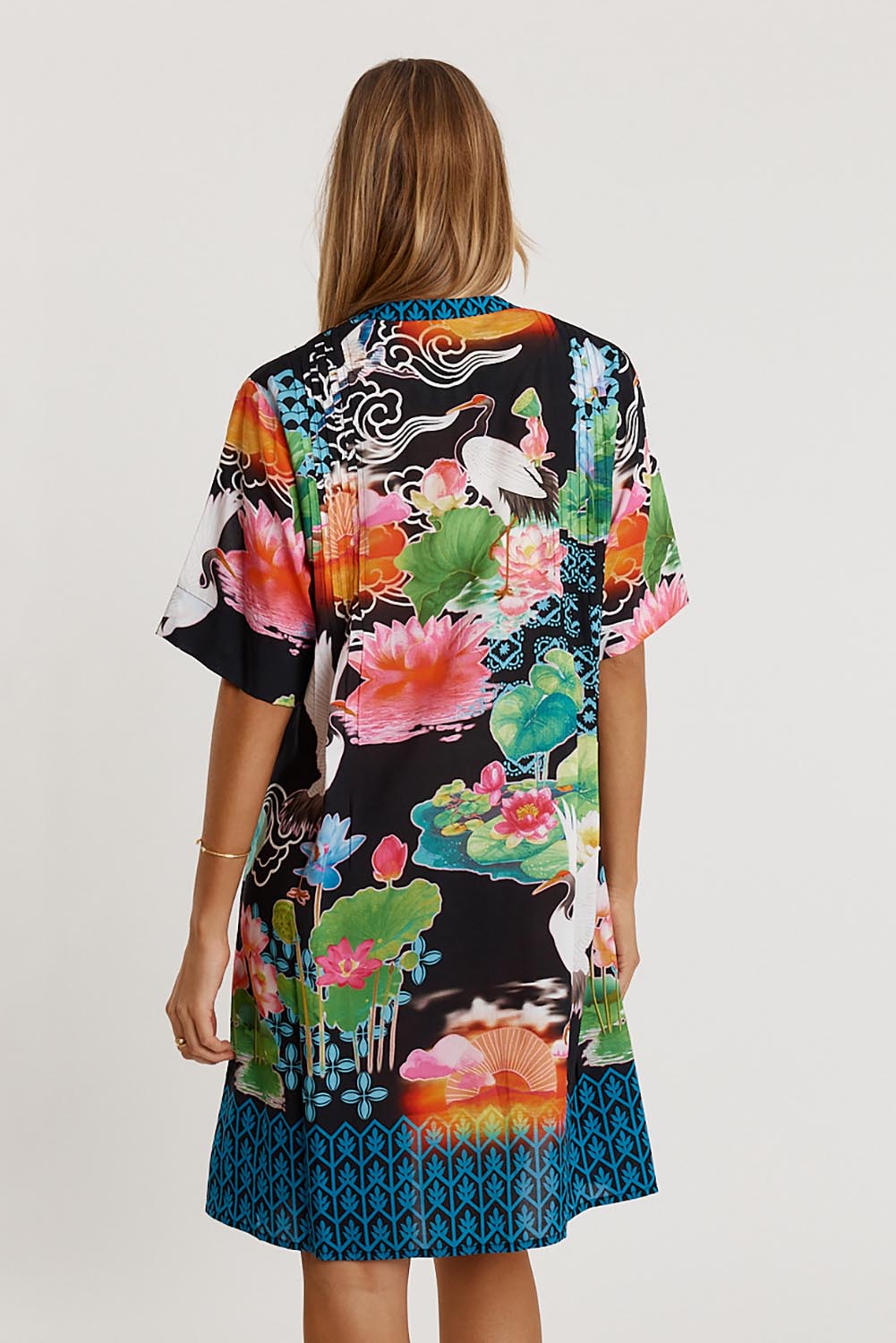 A model wearing the Akiko Button Dress in colour Ocean (Blue), from the back