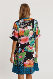 A model wearing the Akiko Button Dress in colour Ocean (Blue), from the back