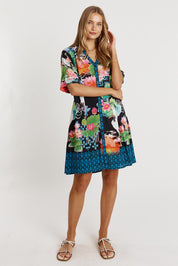 A model wearing the Akiko Button Dress in colour Ocean (Blue), from the front, showing the whole outfit