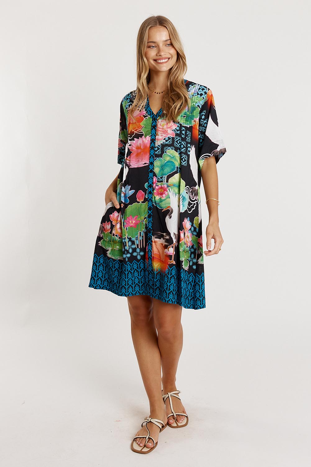 A model wearing the Akiko Button Dress in colour Ocean (Blue), from the front, showing the whole outfit