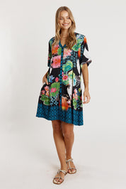 A model wearing the Akiko Button Dress in colour Ocean (Blue), from the front, showing the whole outfit
