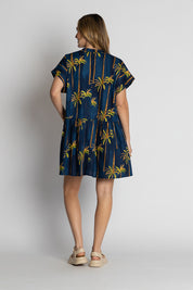 A model wearing the Badira Cotton Dress in colour Navy (Blue), from the back