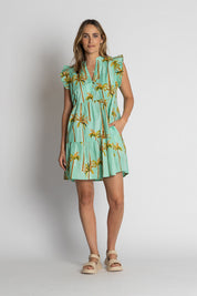 A model wearing the Badira Cotton Ruffle Dress in colour Mist (Green), from the front, showing the whole outfit