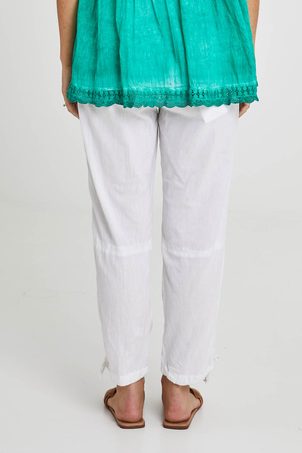 Model Katie wearing size M of the Beach Pant in colour White (White), from the back