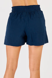 A model wearing the Beach Cotton Short in colour Navy (Blue), from the back