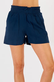 A model wearing the Beach Cotton Short in colour Navy (Blue), from the front, cropped image