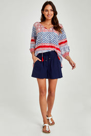 Model Madeline wearing size S of the Beach Short in colour Navy (Blue), from the front, showing the whole outfit