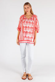 A model wearing the Blakely Cotton Top in colour Melon (Pink), from the front, showing the whole outfit