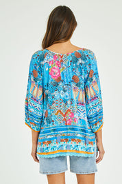 Model Madeline wearing size S of the Carrie Top in colour Sky (Blue), from the back
