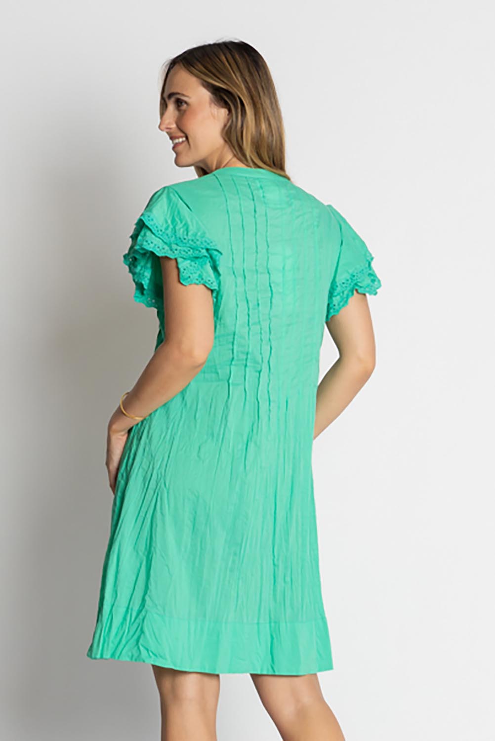 A model wearing the Celeste Ruffle Cotton Dress in colour Sea (Blue), from the back