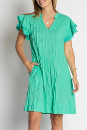 A model wearing the Celeste Ruffle Cotton Dress in colour Sea (Blue), from the front, cropped image
