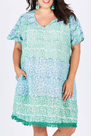 Model Mae wearing size XXL of the Delphi Dress in colour Sea (Green), from the front, cropped image