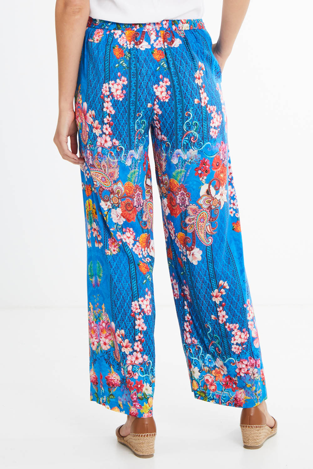 Model Madeline wearing size S of the Frankie Pant in colour Ocean (Blue), from the back