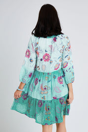 Model Andrea wearing size S of the Jerri Tiered Dress in colour Lagoon (Green), from the back