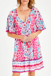 Model Naomi wearing size S of the Jordan Shirred Dress in colour Melon (Pink), from the front, cropped image