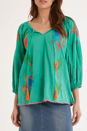 Model Madeline wearing size S of the Mermaid Top in colour Sea (Green), from the front, cropped image