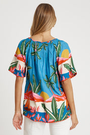 A model wearing the Pacifica Top in colour Print (Blue), from the back