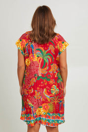 Model Monique wearing size L of the Peregian Dress in colour Melon (Red), from the back