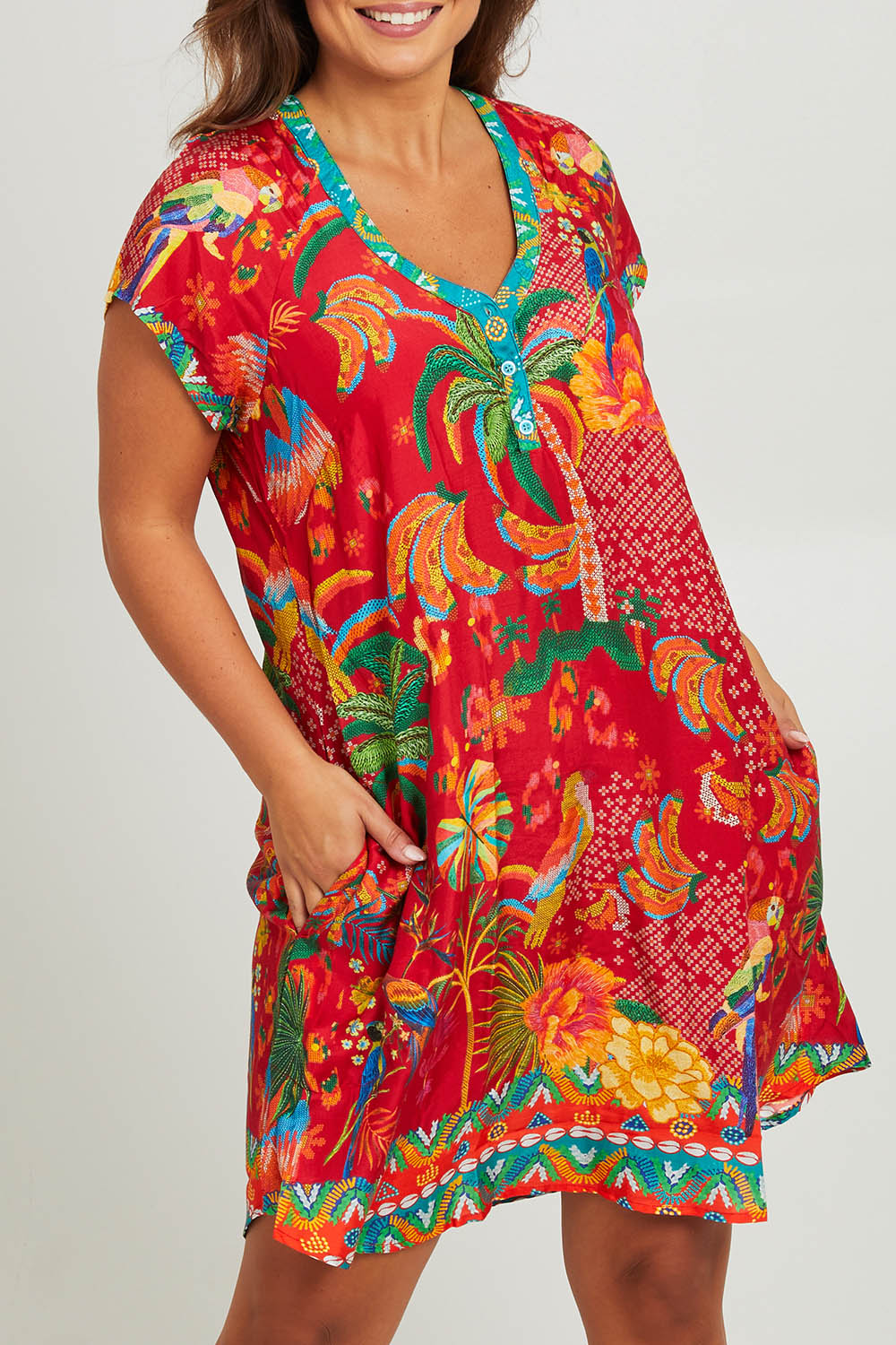 Model Monique wearing size L of the Peregian Dress in colour Melon (Red), from the front, cropped image