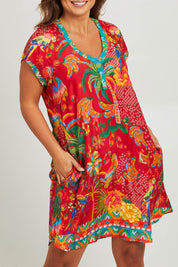 Model Monique wearing size L of the Peregian Dress in colour Melon (Red), from the front, cropped image