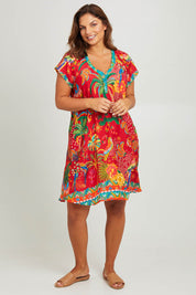 Model Monique wearing size L of the Peregian Dress in colour Melon (Red), from the front, showing the whole outfit