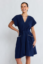 Model Genericm wearing size sample of the Remi Dress – Navy in colour Navy, in a cropped view