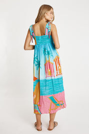 A model wearing the Seraphina Cotton Sundress in colour Mist (Blue), from the back