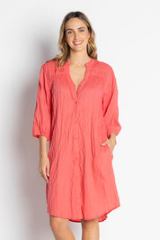 A model wearing the Shayna Cotton Button Dress in colour Geranium (Pink), from the front, cropped image