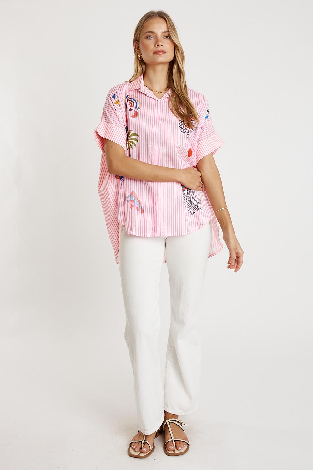 A model wearing the Tillie Cotton Shirt in colour Candy (Pink), from the front, showing the whole outfit