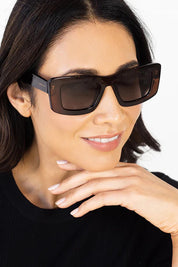 A model wearing the Bailey Sunglasses in colour Brown, from the front, cropped image