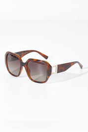 A model wearing size OneSize of the Bessie Sunglasses in colour Tortoise, from the front, showing the whole outfit