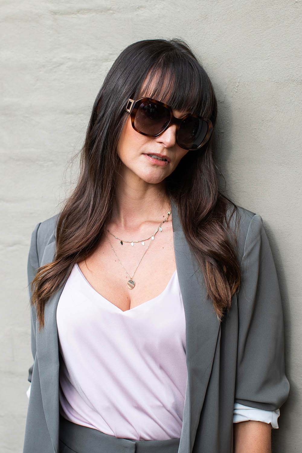 A model wearing the Bessie Sunglasses in colour Tortoise, from the front, showing the whole outfit