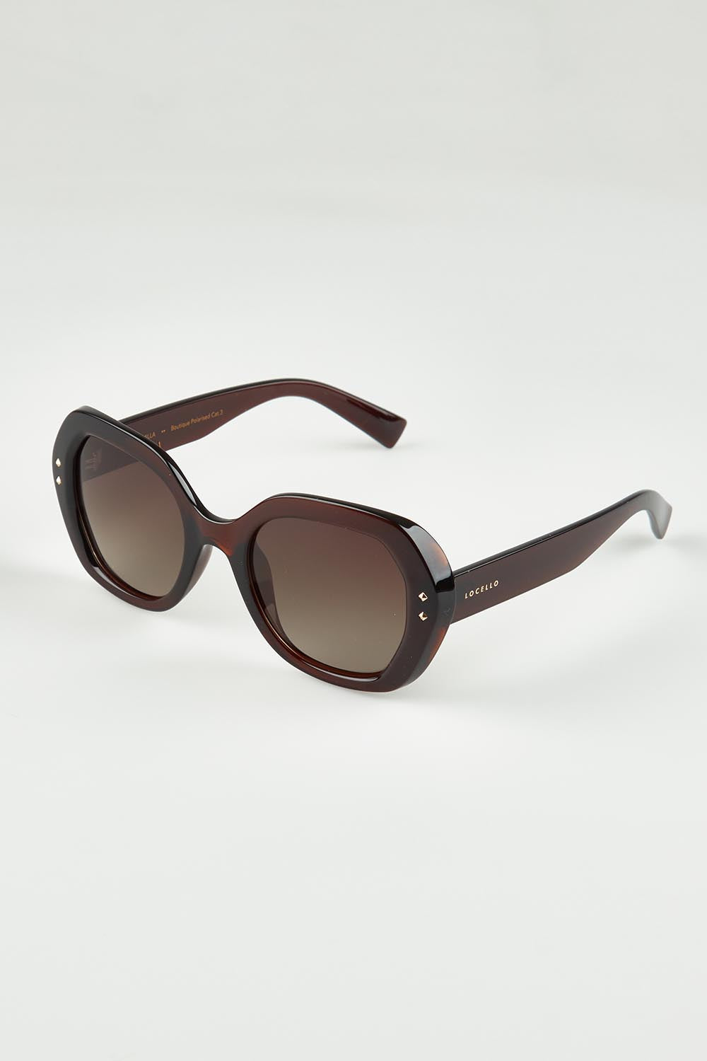 A model wearing the Kamilla Sunglasses in colour Crystbrown, from the front, showing the whole outfit