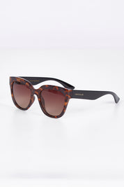A model wearing size OneSize of the Mercedes Sunglasses in colour Tortoise, from the front, showing the whole outfit