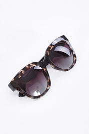 A model wearing size OneSize of the Mercedes Sunglasses in colour Tortoise, from the front, showing the whole outfit