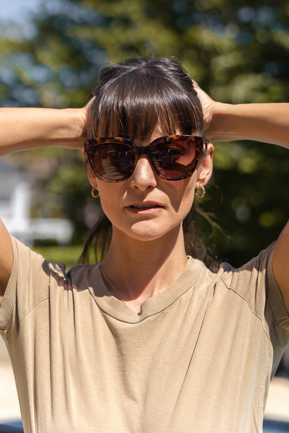 A model wearing the Mercedes Sunglasses in colour Tortoise, from the front, showing the whole outfit