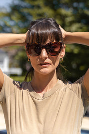 A model wearing the Mercedes Sunglasses in colour Tortoise, from the front, showing the whole outfit