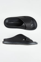 A model wearing size 37 of the Alara Crossover Slide in colour Black (Black), from the front, showing the whole outfit