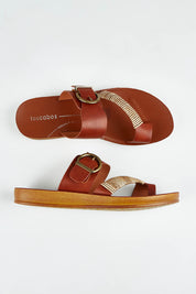 A model wearing size 37 of the Bria Flat Sandal in colour Cognac, from the front, showing the whole outfit