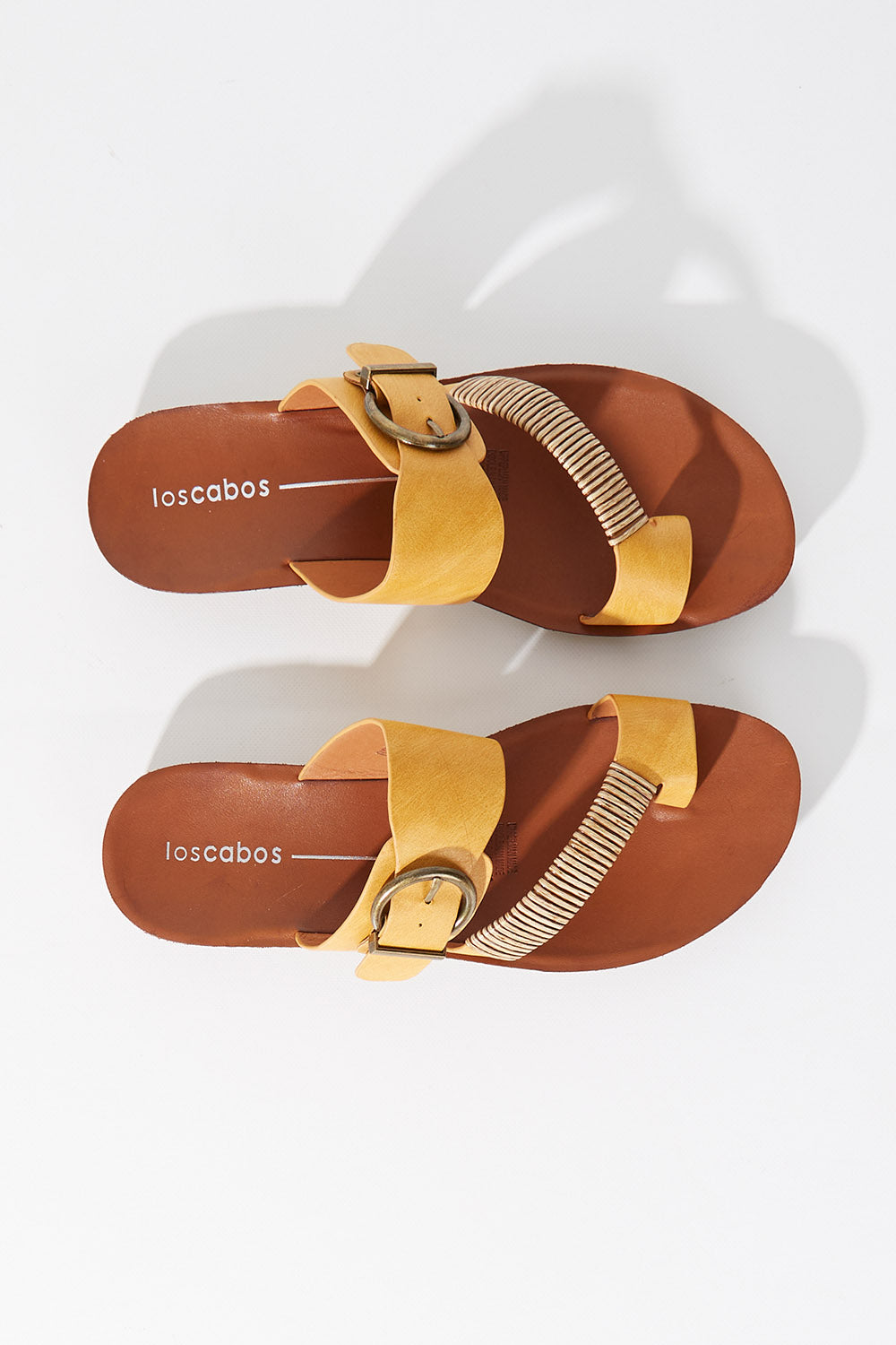 A model wearing size 37 of the Bria Flat Sandal in colour Mustard, from the front, showing the whole outfit