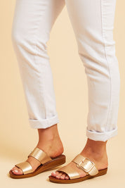 A model wearing size 38 of the Doti Double Strap Slide in colour Softgold (Metallics), from the front, cropped image