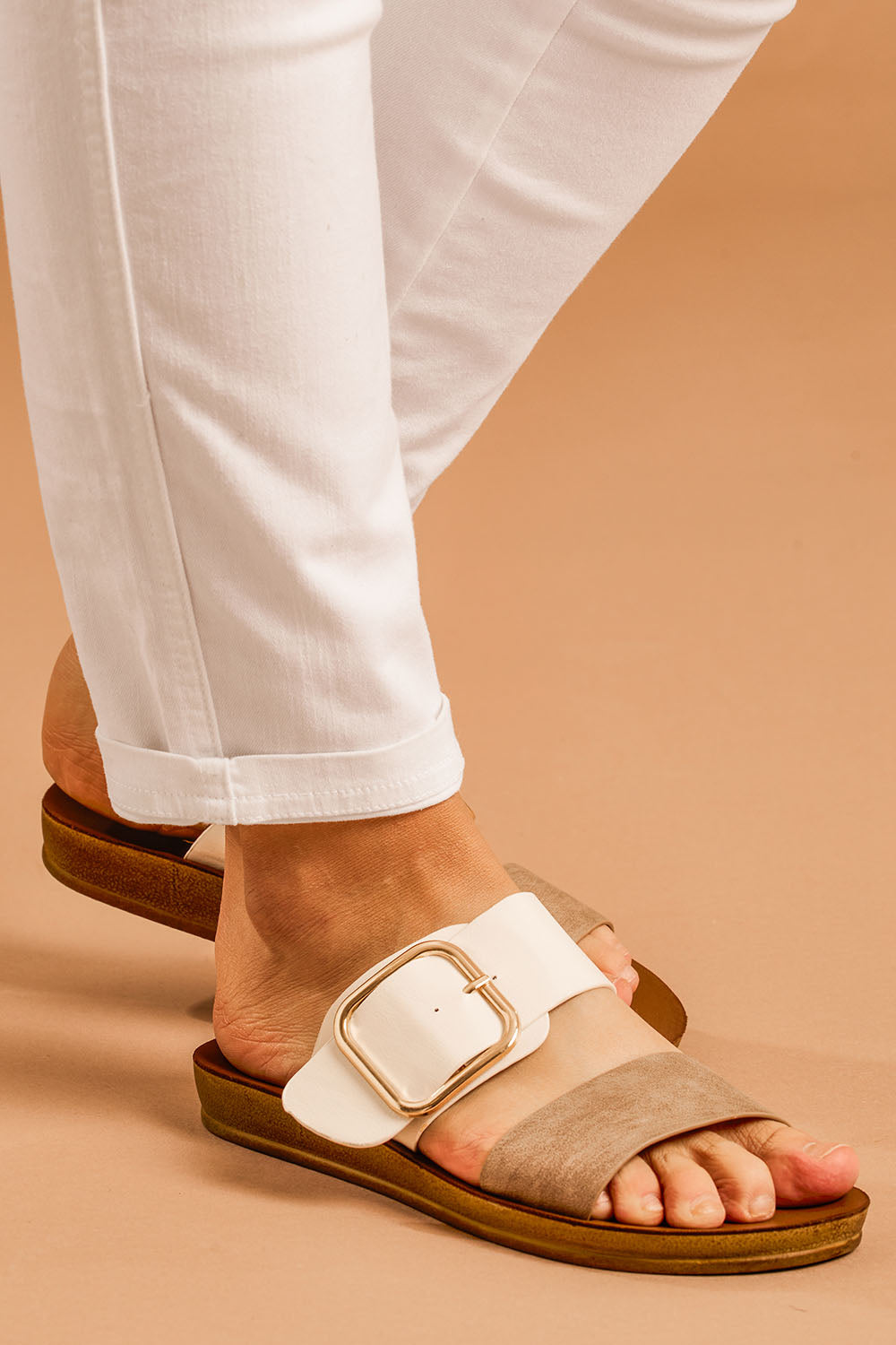 A model wearing size 38 of the Doti Double Strap Slide in colour Taupewhite (White), from the front, cropped image