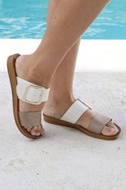 A model wearing the Doti Double Strap Slide in colour Taupewhite (White), from the front, showing the whole outfit